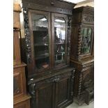 A oak book case cupboard the pair of glazed doors