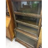 A oak four tier globe wernick bookcase on bun feet