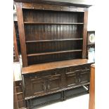 A large oak dresser fitted with three selfs .two d