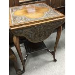 A carved walnut occasional table with four drop fl