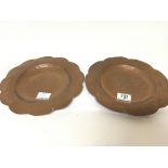 A pair of hand hammered copper Arts and Crafts dishes Newlyn style with shaped edges. 25cm