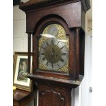 A oak 8 day long case clock the Arched brass dial