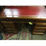 A reproduction pedestal desk fitted with 9 drawers