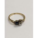 A 18 ct gold diamond and sapphire cross over ring