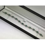 An 18ct white-gold emerald and diamond bracelet. O