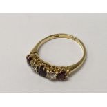 A 5 stone 18ct gold diamond and garnet ring. 2.6g,