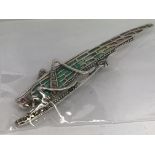 A silver locust brooch set with a pearl in its mou
