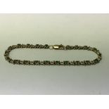 A 9ct gold emerald and diamond line bracelet.