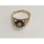A 9 ct gold ring inset with a central pearl surrou