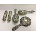 A silver backed dressing table mirror and brushes.