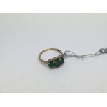 A 9ct gold ring set with 3 green stones and diamon