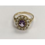 A 9 ct gold ring inset with a central amethyst sur