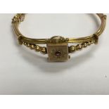 A 9 ct gold Edwardian bangle inset with central ru