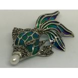 A silver fish brooch/pendant set with a pearl in i