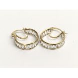 A pair of 9ct gold hoop style earrings set with CZ