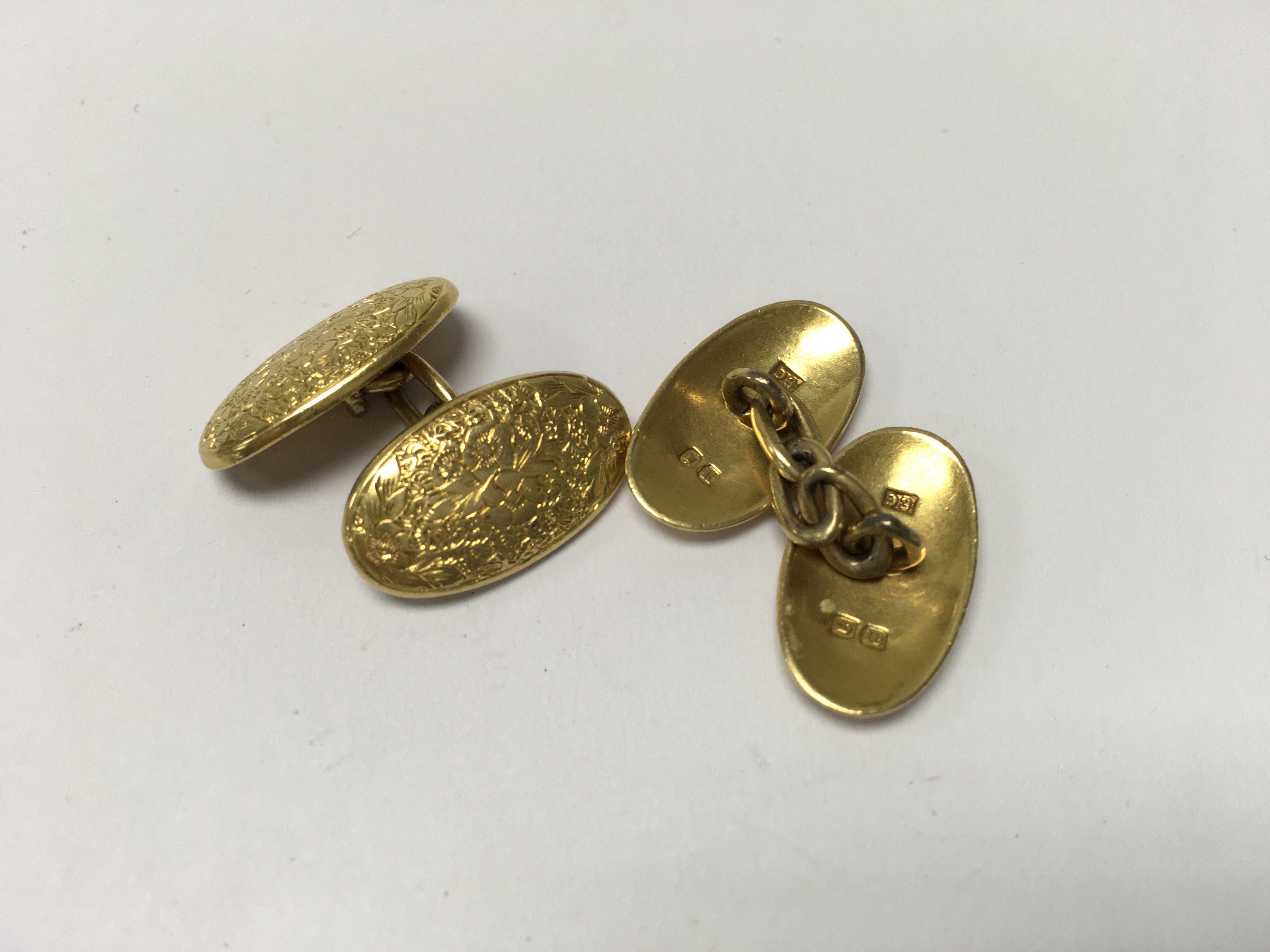 A pair of heavy 18ct gold cuff links with floral e
