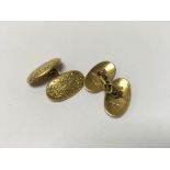 A pair of heavy 18ct gold cuff links with floral e