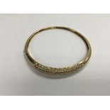 A 18 ct gold bangle inset with numerous diamonds (