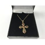 A 9ct gold cross set with garnets on a 9ct gold ch