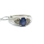 A 9ct white gold ring, the central sapphire surrou