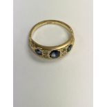 A gold ring inset with three sapphires and four di