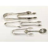 A group of five silver sugar tongs of various size