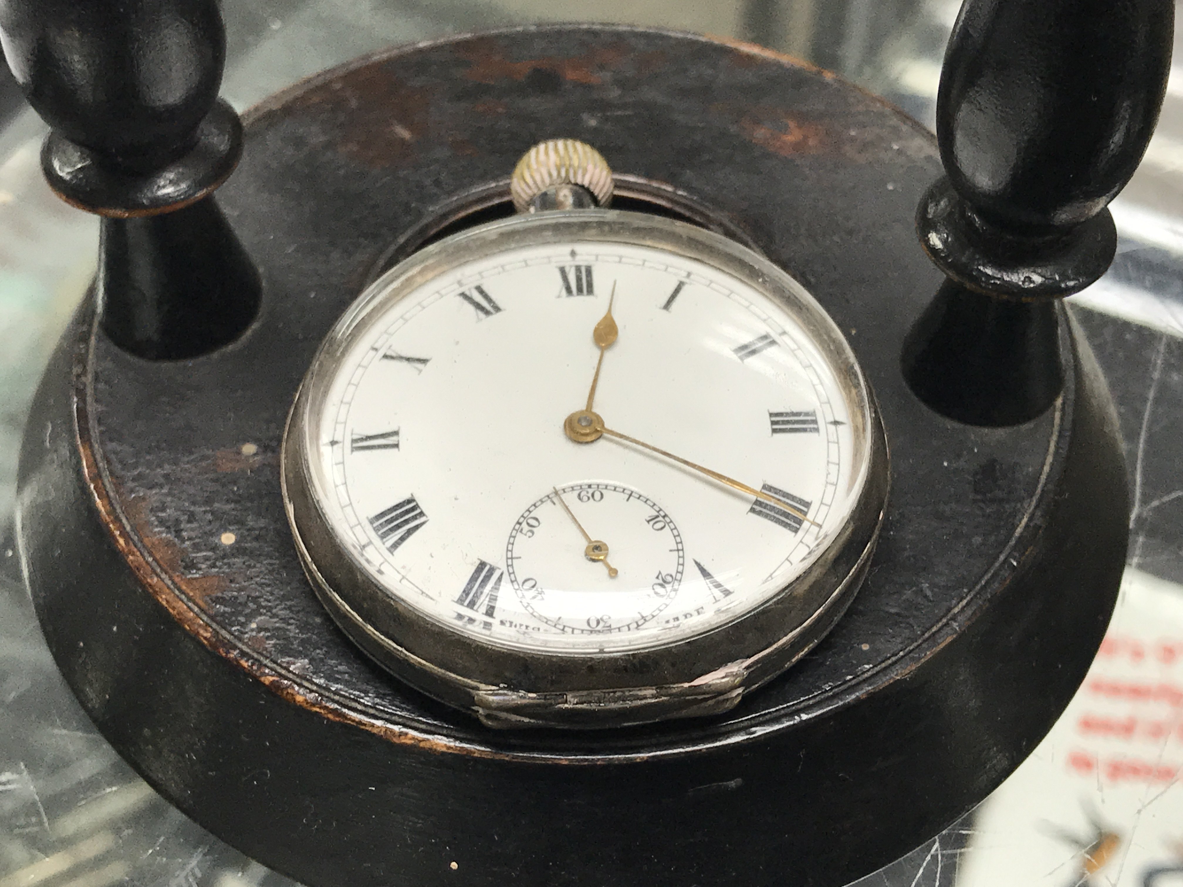 A hallmarked silver pocket watch and turned wooden pocket watch stand