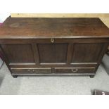 A oak blanket chest the hinged top and panelled front above two drawers.
