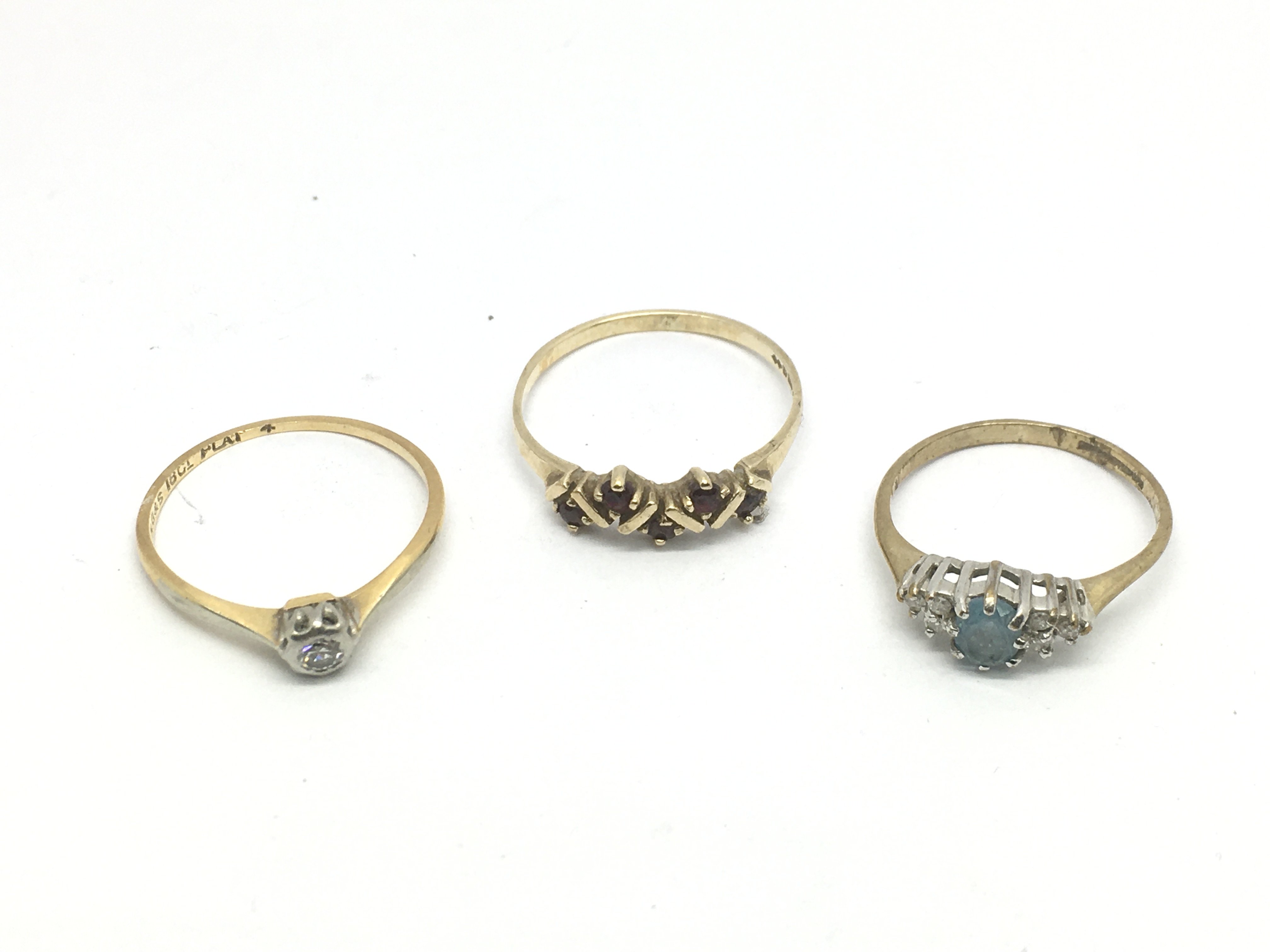 Three gold rings, set with various stones includin