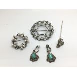 A small group of silver brooches and earrings.