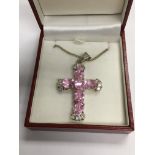 A silver cross set with white and pink stones and