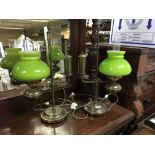 A pair of brass library lamps with green glass sha