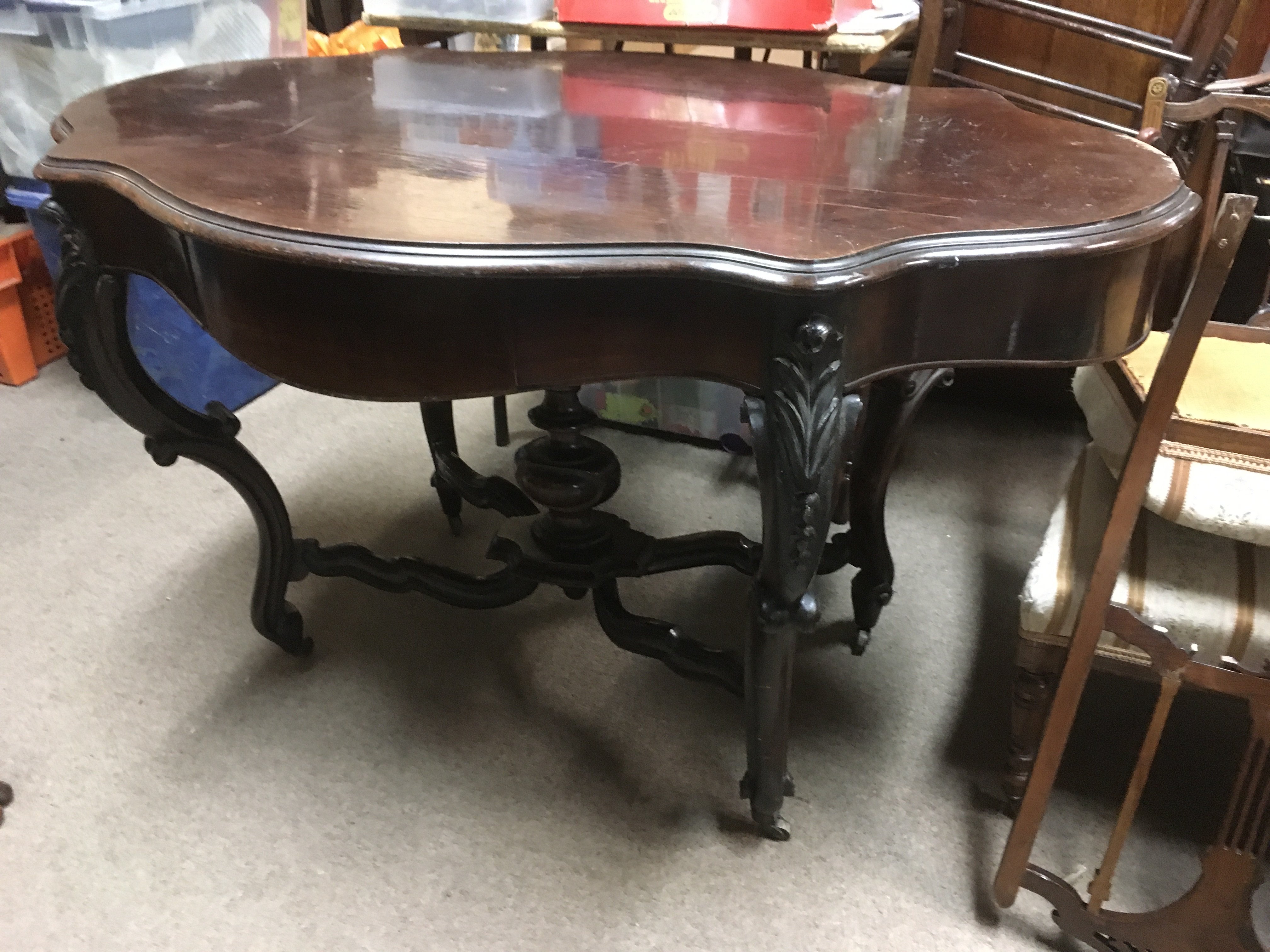 A 19th Century rosewood table with shaped top, som
