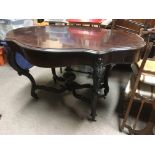 A 19th Century rosewood table with shaped top, som