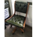 A office chair with with green button back and sea