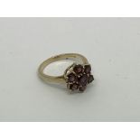A 9ct gold ring set with 7 garnet stones. Size o a