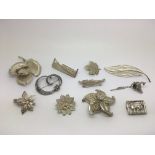 Eleven silver brooches, various designs.