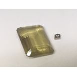 An Emerald cut green stone unmounted and a small d