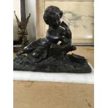 A bronze figure in the form of a reclining child r