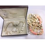 A boxed mother of pearl necklace with matching ear