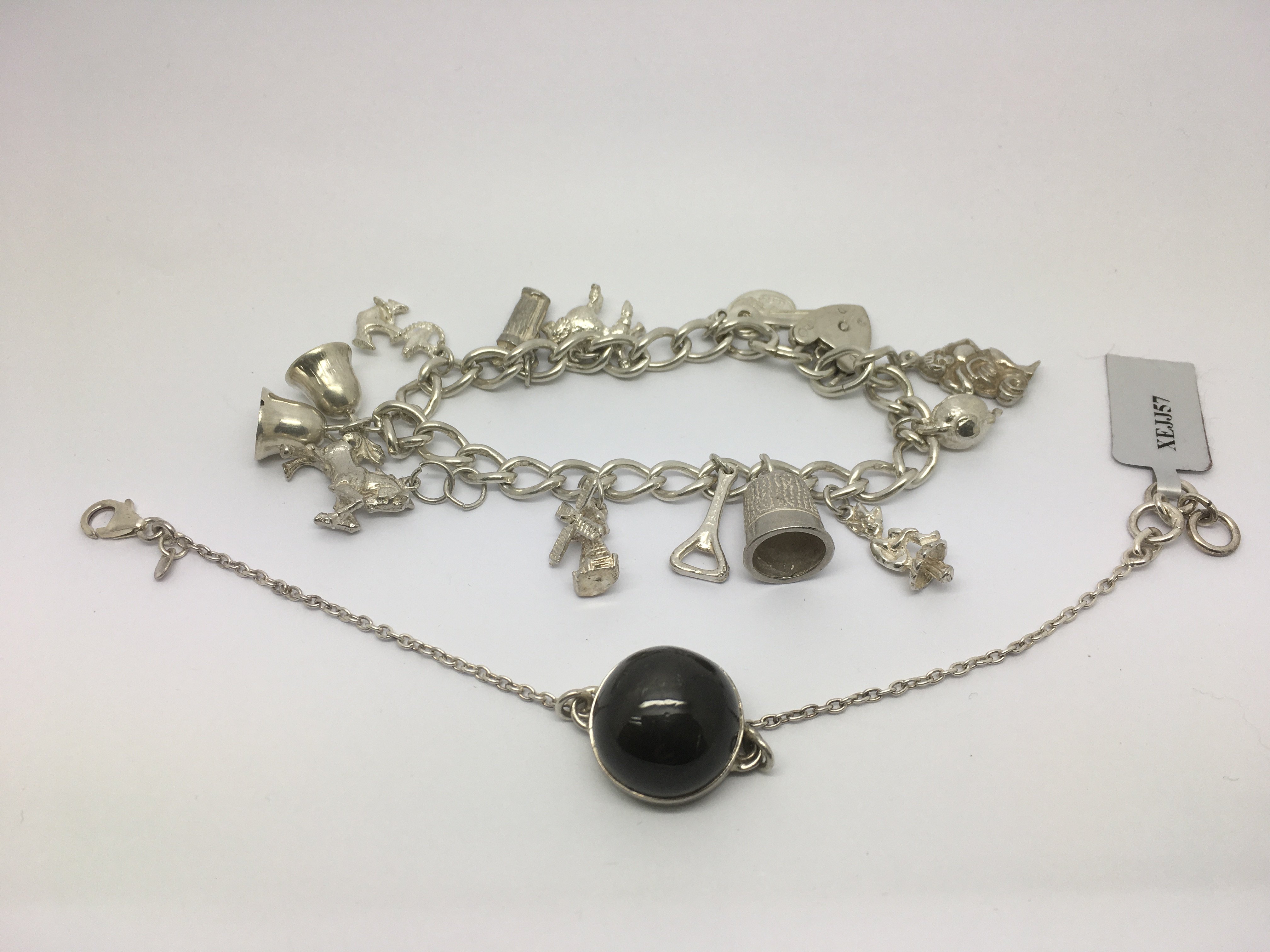 A silver charm bracelet and a beryl stone pendant