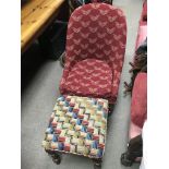 A red upholstery Victorian nursing chair with a small upholstered foot stool.