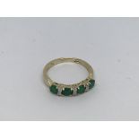 A 9ct gold ring set with 4 emeralds and 6 small di