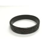 A carved Chinese bangle and a white metal patterne
