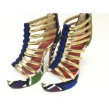 A pair of Christian Louboutin designer high heel shoes with applied velvet pattern gold open straps.