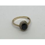 A 9ct gold ring set with a sapphire and diamond cl