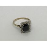 A 9ct gold ring set with a square sapphire and dia