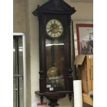 A late 19th century Vienna wall clock with an enamel dial and visible pendulum. With two weights.