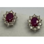 A pair of 18ct white gold ruby and diamond cluster