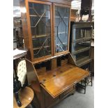 An Edwardian inlaid walnut bureau bookcase with gl